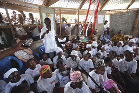 A young man shares his experience during a community gathering on gender at the Women’s Peace Hut in Bong County, Liberia