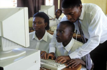Teacher showing secondary students how to use computers