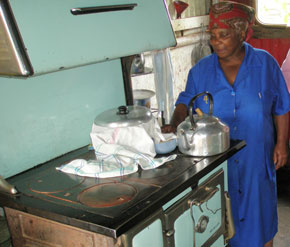 Resident of Soweto’s Motsoaledi shantytown, standing by her vintage wood-burning stove