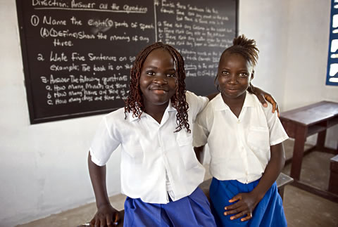 2 Liberian schoolgirls in front of a blackboard
