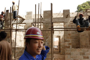 A Chinese foreman walks past a construction site in Guinea-Bissau