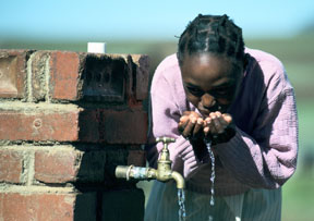 Woman drinking from a tap