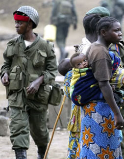 Soldiers walking near two mothers with young children