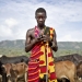 A Kenyan teacher checks his mobile phone while guarding his cattle. Photo: Panos/Sven Torfinn