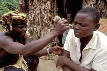 A traditional healer in Uganda treating a patient’s dizziness