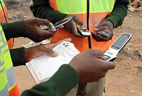 Non-governmental peace workers sharing information by cell phone to help monitor