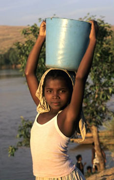 Girl fetching water from a river in Madagascar