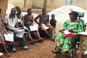 Image of village discussion led by a woman with a disability