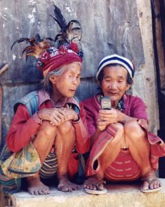 Two older ladies with vision impairments inspect a mobile phone