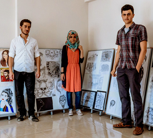 Students standing next to their art work