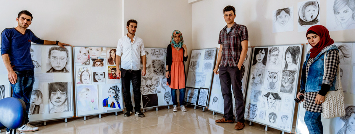 Students standing next to their art work