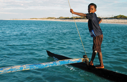 young boy standing with a fishing stick