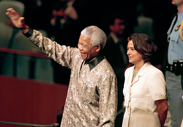 南非总统纳尔逊•罗利拉拉•曼德拉（左）进入联大会堂准备在大会第五十三届会议上发表演讲。陪同他的是联合国礼宾处处长娜迪亚•优尼斯。