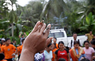 A close-up of a hand holding a cigarette.