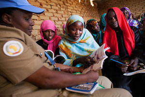 Tutores voluntários ensinar a ler em mulheres inglesas em um acampamento para deslocados internos em Darfur do Norte.