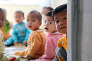 Unos niños sentados en un salón.