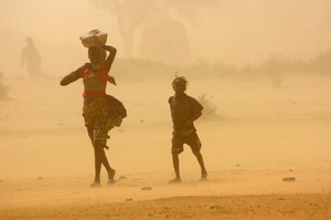 Una mujer y un niño caminando en el desierto.