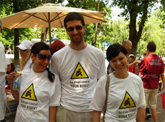 Tres jóvenes usando camisetas con la leyenda: ¿Controlan las drogas tu vida?