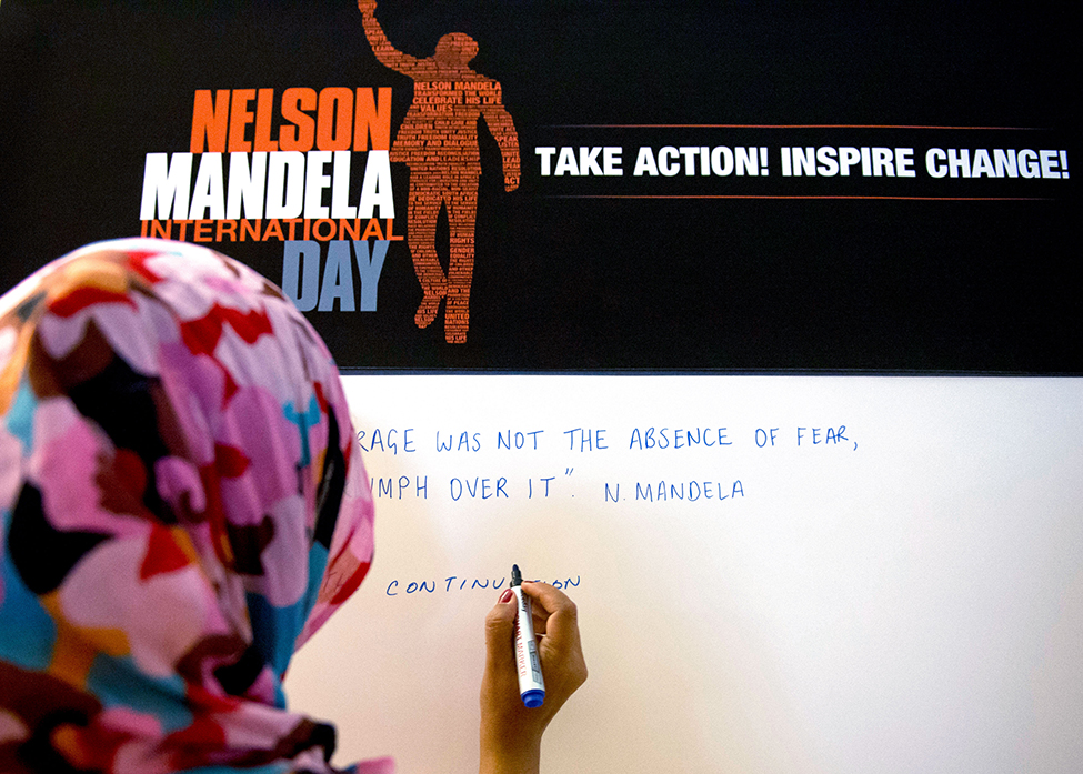 Un participante escribe un mensaje en un tablón de conmemoración del Día Internacional de Nelson Mandela.