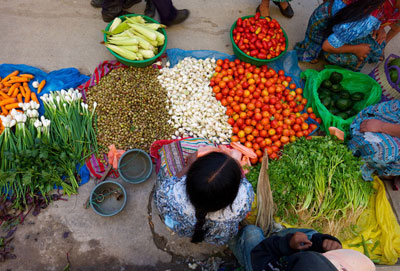 Un miembro de una cooperativa agrícola vende verduras en un mercado de Guatemala. El objetivo de reducir el hambre tiene el potencial de lograrse al final de 2015, dice la ONU. FIDA/Santiago Albert Pons