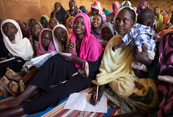 Las mujeres y los niños asisten a una clase de inglés respaldado por la ONU en un campamento para los desplazados internos en el norte de Darfur, Sudán. ONU/Albert González Farran