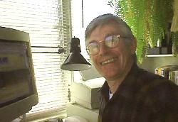 Image of John Mathiason seated in front of his computer.