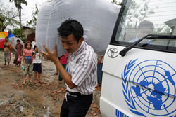 Сотрудник УВКБ  раздает одеяла жертвам циклона «Наргис». Мьянма, 16 мая 2008 года.