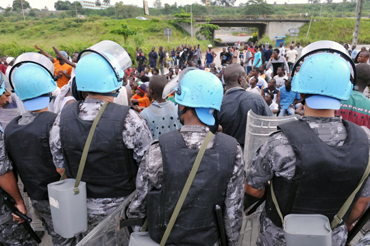Участвующие в политических демонстрациях граждане Кот-д'Ивуара ищут защиты и медицинской помощи у служащих расположенного неподалеку иорданского сформированного полицейского подразделения, 2010 год. Фото ООН/Базиль Зома