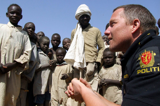 Полицейский ООН из Норвегии беседует с жителями лагеря для перемещенных лиц в Дарфуре, Судан, 2006 год. Фото ООН