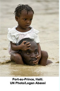 A father carries his daughter on the shoulders as residents flee rising waters in search of shelter, after heavy rains caused by tropical storm 'Noel' flooded their homes in Cité Soleil, Haiti. UN Photo/Logan Abassi