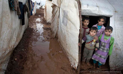 Syrian children stand in the entryway of their tent shelter in the Bab Al Salame camp for internally displaced persons in Aleppo Governate. Photo: UNICEF/Giovanni Diffidenti