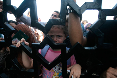 A young girl waiting to cross into Egypt with her family cries at the Rafah Border Crossing in southern Gaza. © UNICEF/NYHQ2014-0902/El Baba