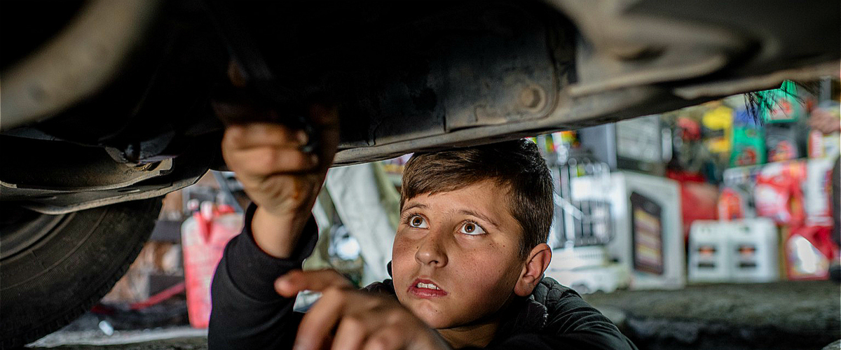 14岁的叙利亚难民穆罕默德在伊拉克埃尔比勒的一家汽车维修店工作。