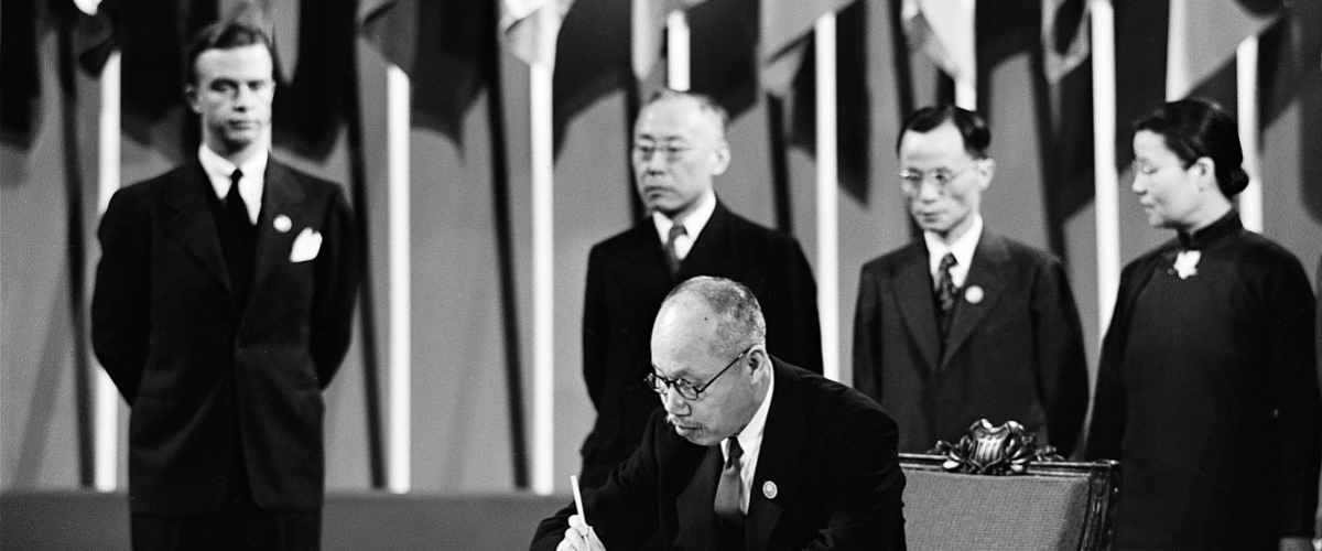 中国代表董必武用毛笔在《联合国宪章》上签字。美国旧金山退伍军人纪念堂，1945年4月26日。联合国图片/McCreary