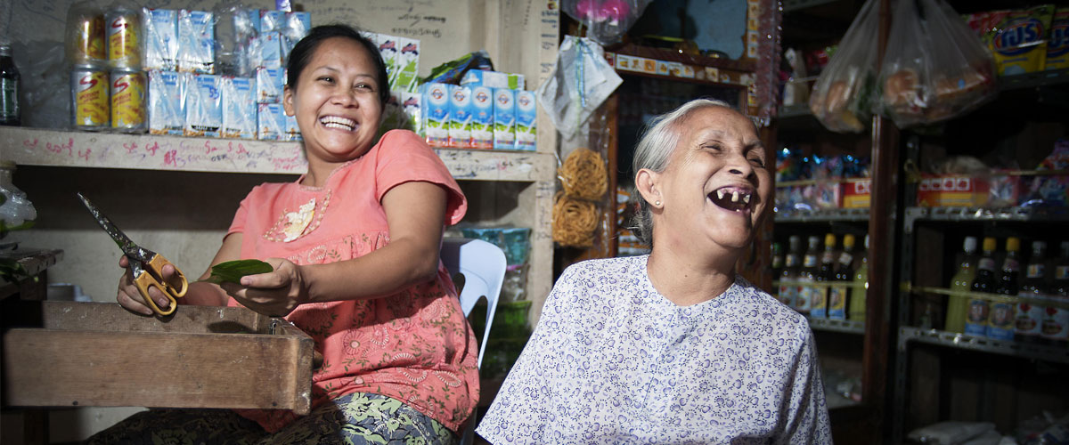 在缅甸大其力一家杂货店里，一位七旬老妇人与家人开怀大笑。联合国图片/Kibae Park