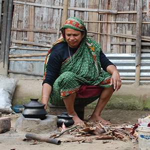 Woman cooking a meal outside her house in a Boliar Bagh village, Sylhet province, Bangladesh.