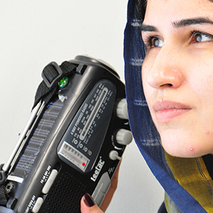 >一名年轻女性正在收听广播。图片来源：巴基斯坦联合国信息中心