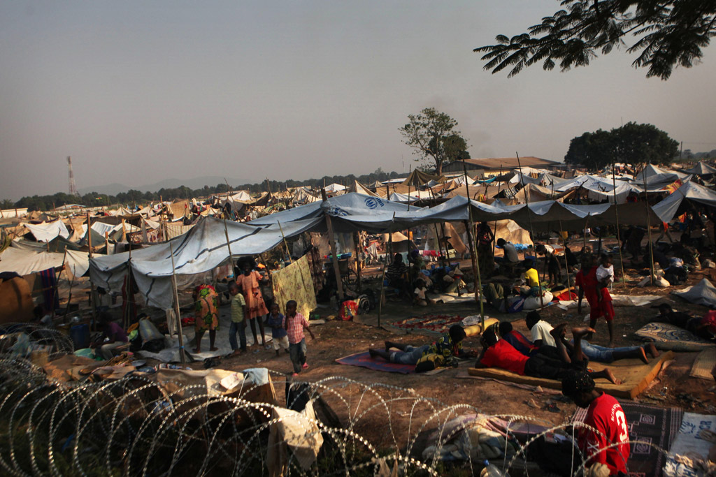 Des enfants et des adultes déplacés dans un camp derrière l’aéroport de Bangui, en République centrafricaine (RCA). 