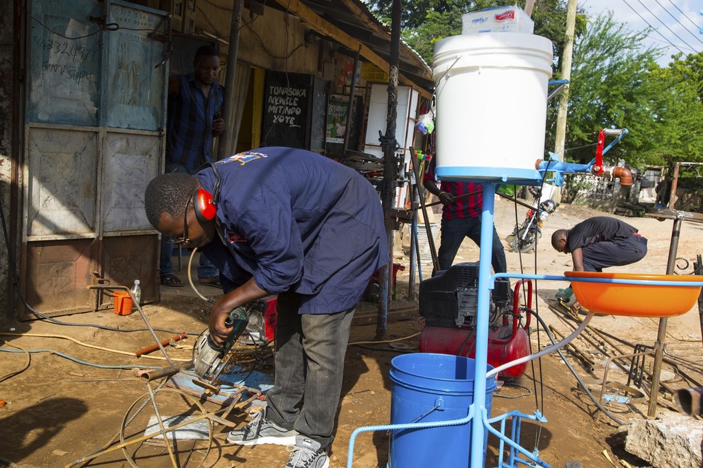 Kijana Tanzania atengeneza ndoo ya kunawa mikono bila kugusa koki wala sabuni.