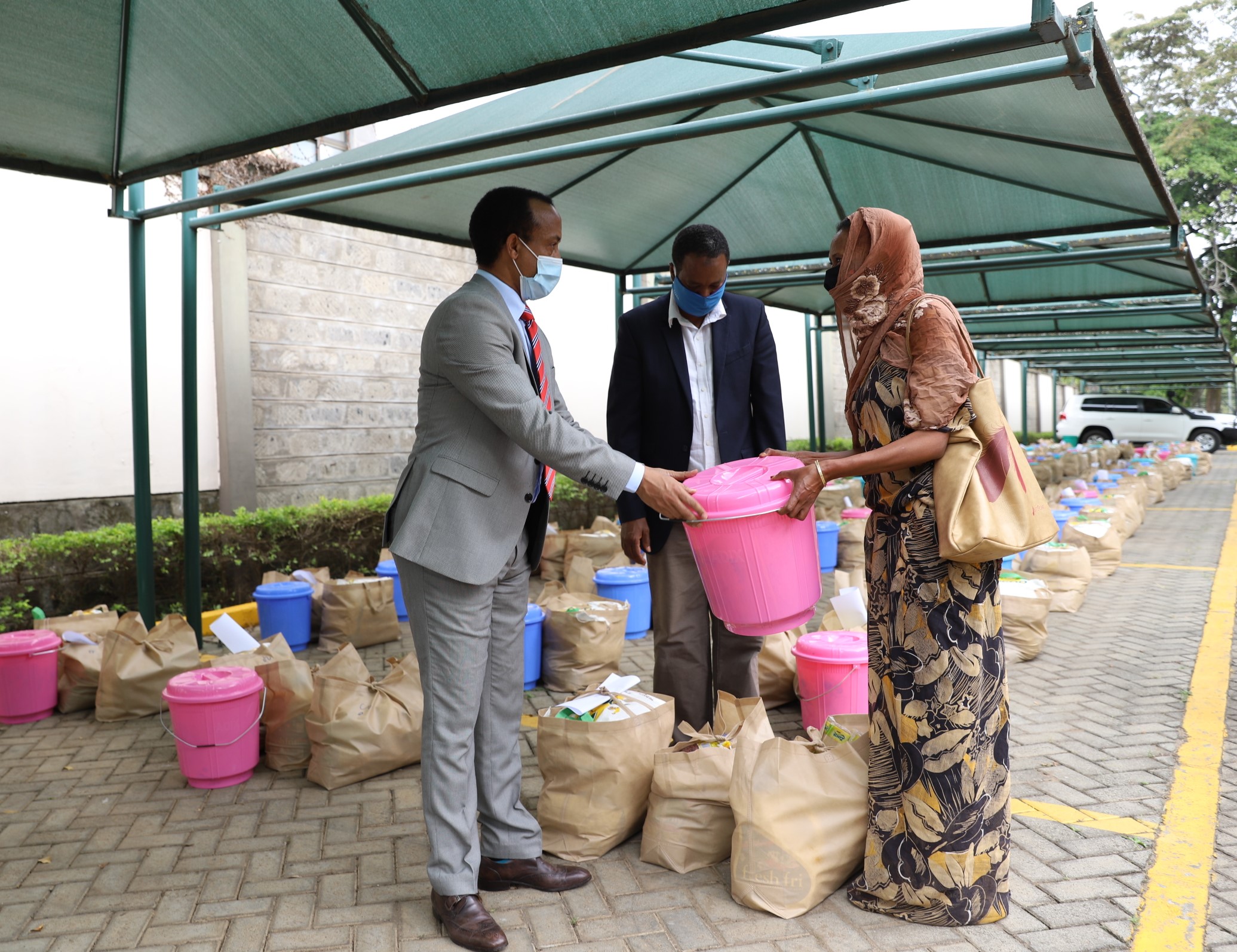 Meles Alem, Ethiopian Ambassador to Kenya handing over food donation to one of the beneficiaries.