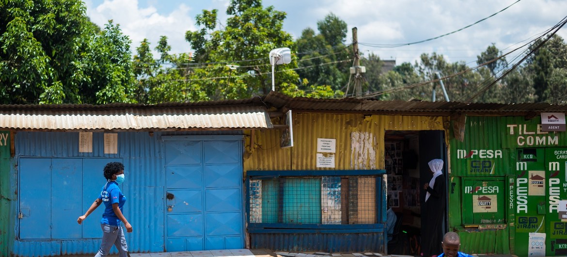 Grace akipita mbele ya duka lililofungwa akiwa anaelekea sokoni Kibera kuelimisha jamii jinsi ya kujikinga na Corona.