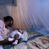 Nourrisson entouré d'une moustiquaire protectrice contre le paludisme au Ghana.