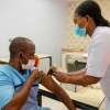 Une infirmière administre une deuxième dose du vaccin COVID-19 à un bénéficiaire.