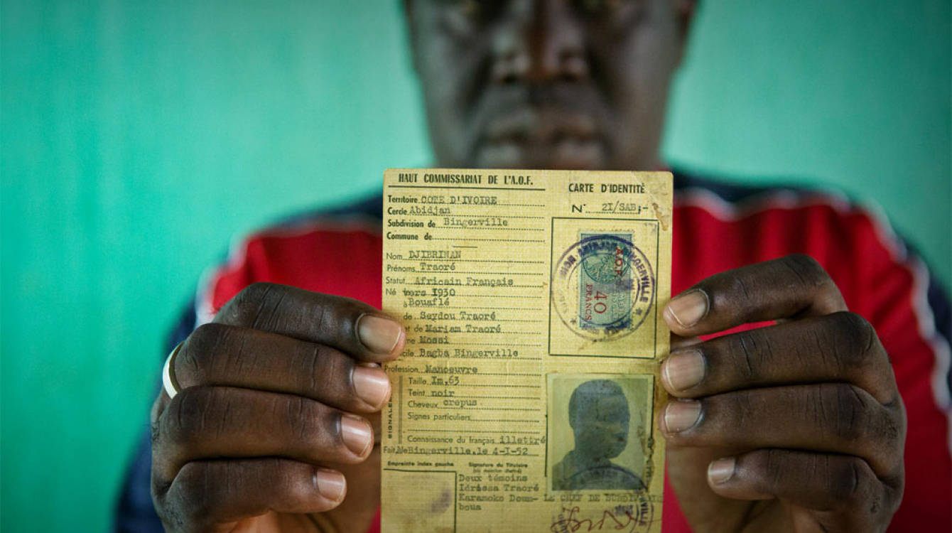 Un homme répondant au nom de Oumar, qui risquait de devenir apatride, brandit la carte d’identité de son père, datant de l’époque coloniale française. Photo : HCR/Hélène Caux