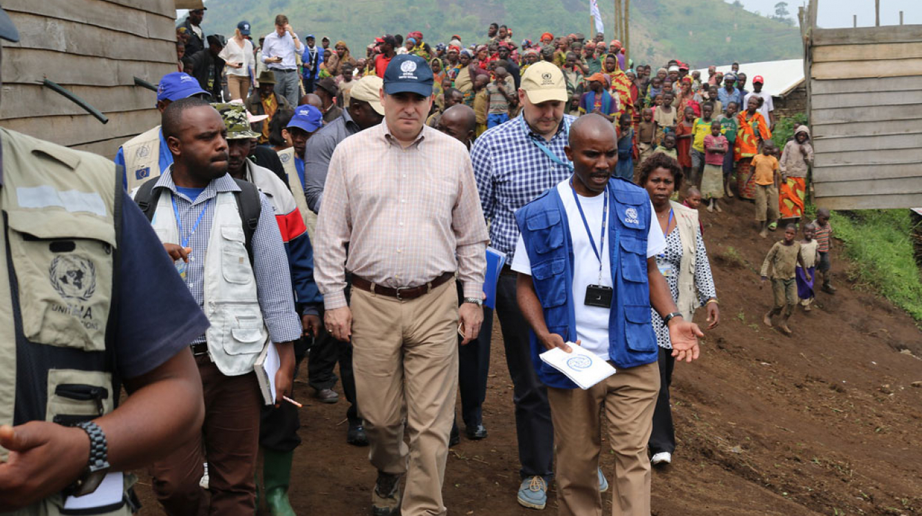 Operations Director of the Office of the Coordination of Humanitarian Affairs (OCHA), John Ging (centre), walks around the Kanaba IDP site in the Democratic Republic of the Congo (DRC) during a visit on 24 June 2016. Photo: OCHA/Vicky Prekabo