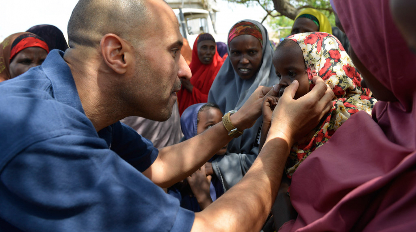 World Health Organization (WHO) official, Dr. Ahmed El Ganainy, checks the eyes of a little girl during a joint humanitarian assessment mission to Marka, Somalia, on 9 July 2014. UN Photo/David Mutua