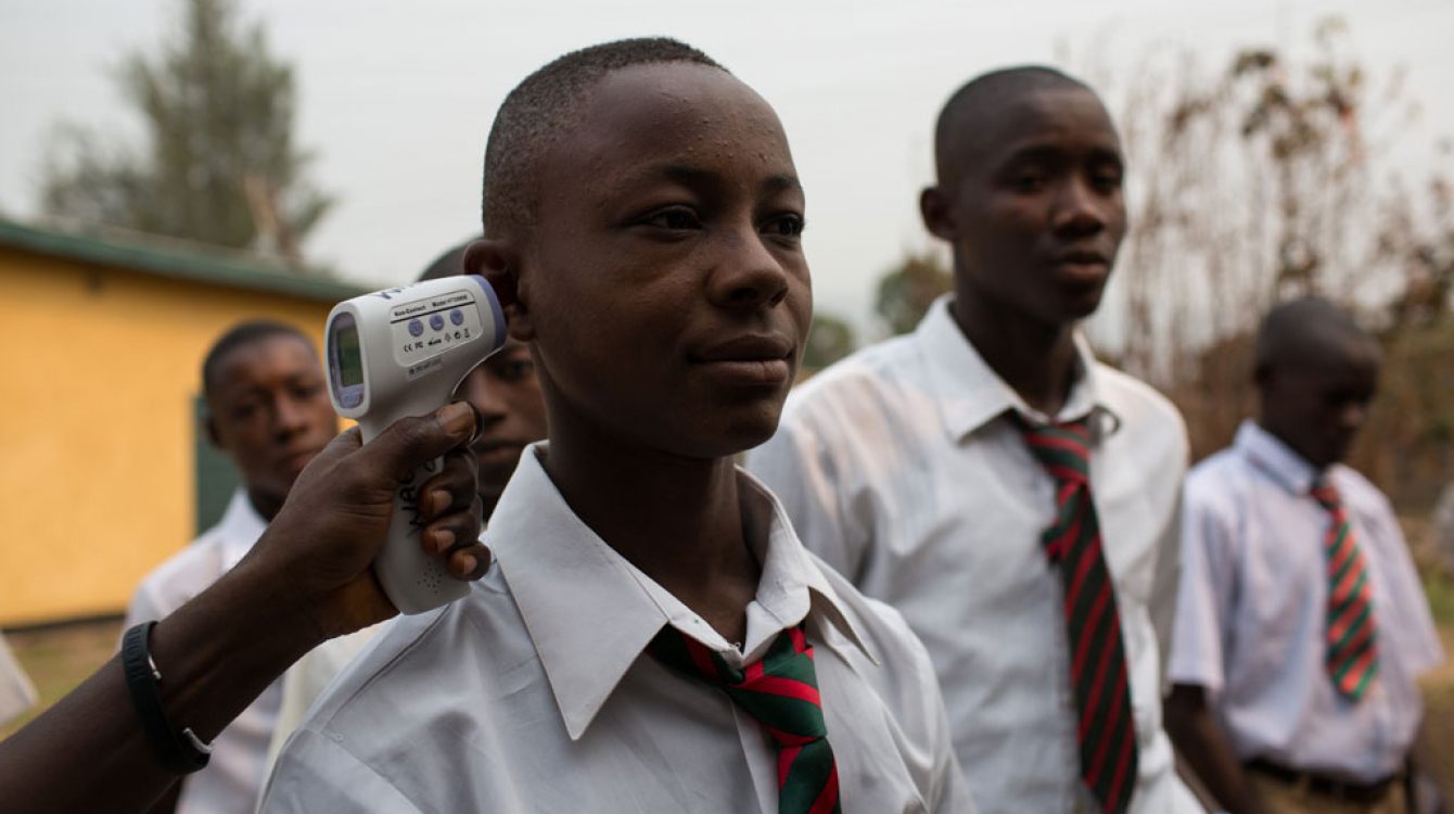 Un garçon prend sa température en mars 2015 alors qu’il arrive à l’école à Kenema, en Sierra Leone, dans le cadre des efforts de dépistage d’Ebola.