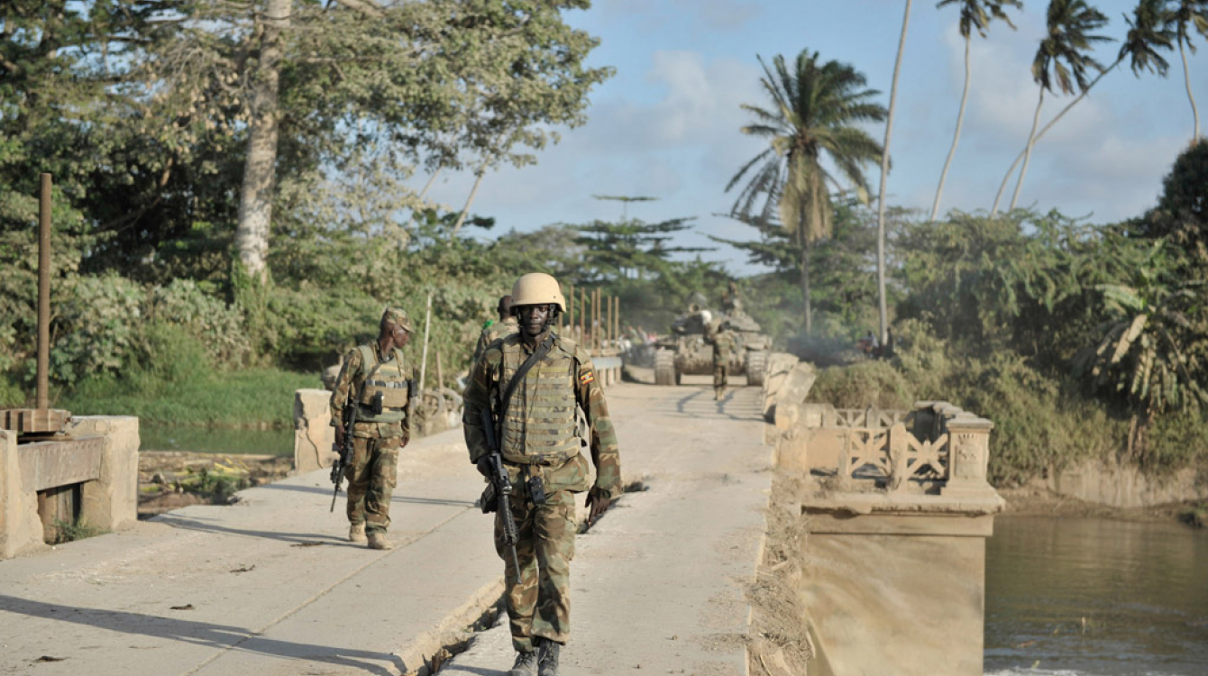 Ugandan soldiers serving with the African Union Mission in Somalia (AMISOM), walk across a bridge near the town of Janaale, Somalia.