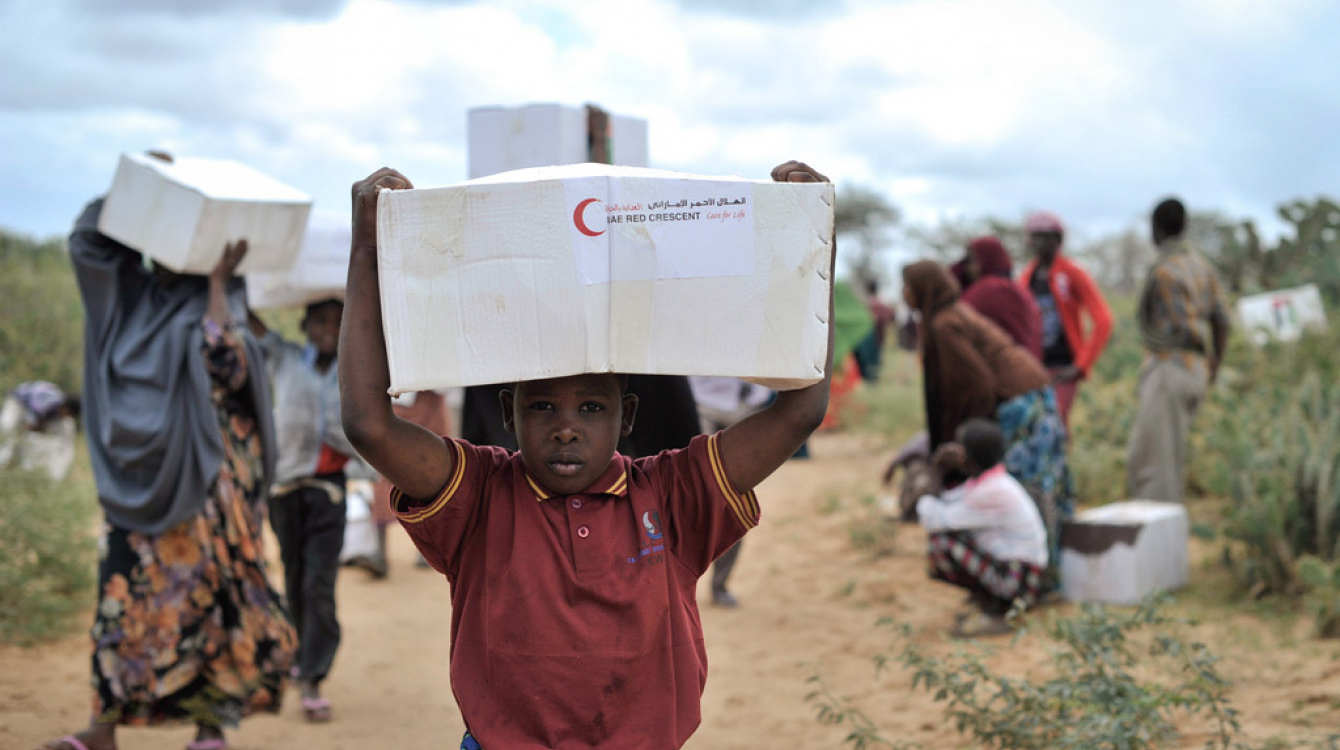 A young boy carries away a box of food from a distribution centre in Afgoye, Somalia. Photo: AU/UN/IST/Tobin Jones