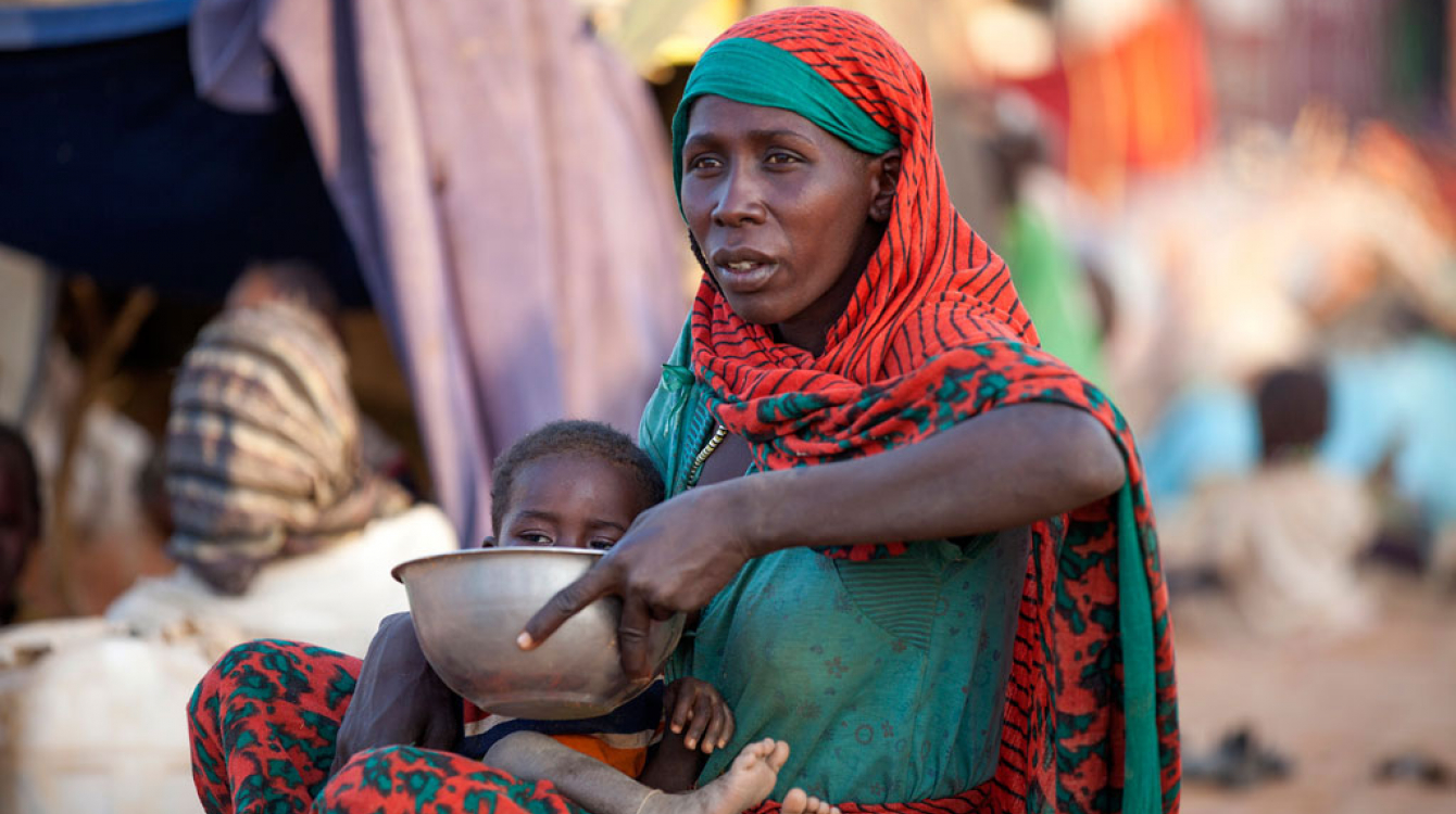 A displaced mother prepares food for her child outside the UNAMID base in Um Baru, North Darfur. UN Photo/Hamid Abdulsalam